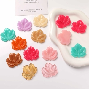Detailed view of colorful resin maple leaf charms with intricate leaf vein patterns for DIY crafts