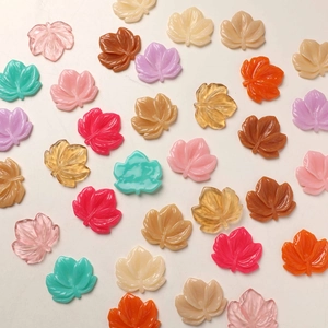 Detailed view of colorful resin maple leaf charms for DIY jewelry and crafts