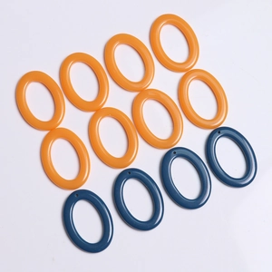 Flat lay of oval resin charms in bright orange and deep blue colors with top holes