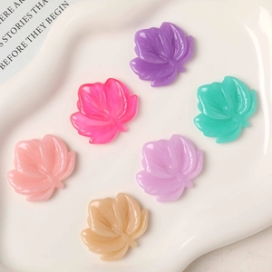 Macro detail of colorful resin maple leaf charms with delicate veins for DIY crafts