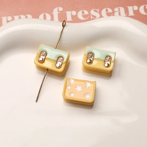 Primer plano de mini dijes de bolso de resina con agujeros para joyería artesanal