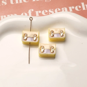 Detalle de dijes de mochila de resina macaron con hebillas doradas para joyería DIY
