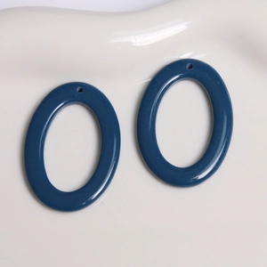 Close-up of dark blue oval resin pendants with glossy finish for DIY jewelry crafting