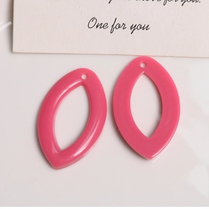Vue macro de breloques en résine rose en forme de feuille pour la création de boucles d'oreilles