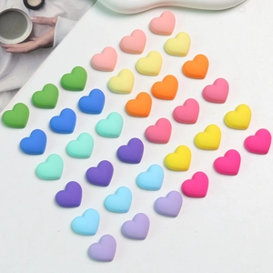 Detailed view of colorful matte heart-shaped acrylic beads for DIY jewelry making