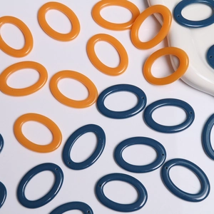 Close-up of oval resin jewelry connectors in orange and navy with pre-drilled holes for DIY