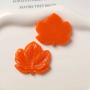 Detailed view of orange maple leaf resin charms with veins for DIY jewelry