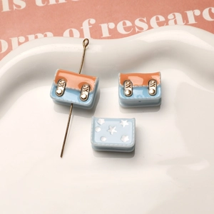 Detalle macro de colgantes de mochila de resina azul y naranja para joyería y tocados DIY