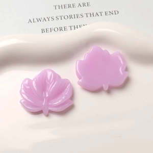 Detailed view of pink resin maple leaf charms with realistic veins for DIY jewelry