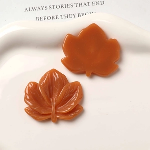 Detail of amber resin maple leaf charms with realistic vein textures for DIY jewelry