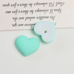 Detail showing matte mint green and white acrylic heart beads for DIY jewelry making