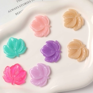 Macro view of colorful resin leaf charms in various pastel tones for DIY jewelry making