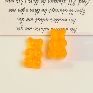 Close-up of orange translucent resin bear charms for DIY jewelry making and crafts