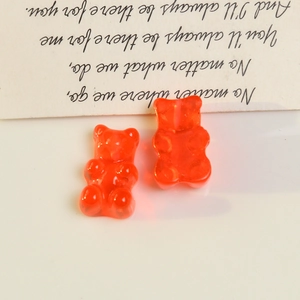 Macro shot of two transparent orange resin bear charms for DIY jewelry and accessories