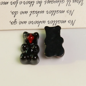 Macro shot of resin bear charms with red hearts for DIY jewelry and hair accessories
