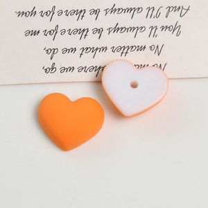 Close-up of heart-shaped macaron acrylic charms for DIY jewelry and earring making