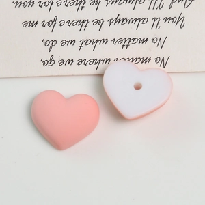 Macro view of matte heart-shaped acrylic beads with center holes for DIY jewelry making
