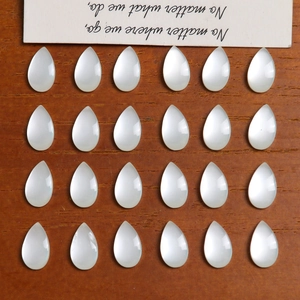 Pear-shaped cat eye stone beads for DIY jewelry making on a wooden background