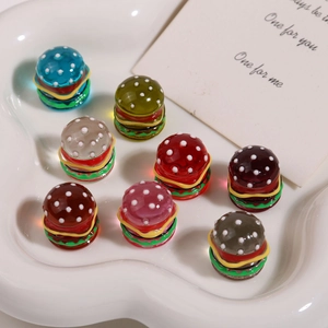 Macro shot of colorful resin hamburger charms in a heart-shaped tray for DIY jewelry
