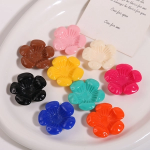 Dettaglio di fiori colorati in resina per gioielli fai-da-te in un piatto di ceramica