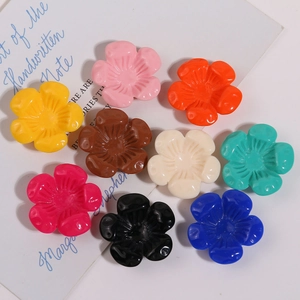 Dettaglio di ciondoli a forma di fiori colorati in resina a cinque petali per artigianato DIY