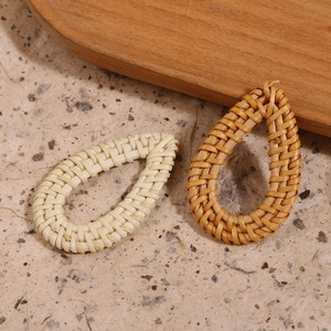 Detalle macro de colgantes de gota en ratán hechos a mano en crema y marrón para joyas