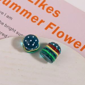 Macro shot of 3D resin hamburger DIY bead with glossy blue polka dot finish and vibrant layers