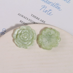 Makroansicht hellgrüner Harzrosenblüten für DIY-Zubehör auf einem eleganten weißen Teller