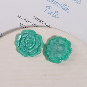 Detailansicht von zwei grünen Harzrosen mit Steintextur auf einem Keramiktablett