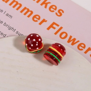 Detailed macro view of two mini 3D resin hamburger beads for DIY earring and hair craft