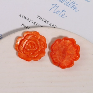 Makroaufnahme von 2 orangefarbenen Harz-Kamelienblüten mit Marmortextur für DIY-Schmuck