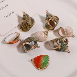 Détail de breloques en coquillage naturel avec bordure dorée pour bijoux faits main
