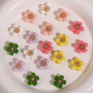 Colorful alloy flower beads in a ceramic bowl for DIY jewelry making and crafts