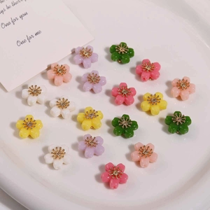 Flat lay of colorful alloy flower charms with gold stamens for DIY jewelry making