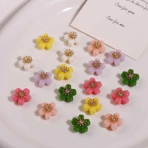 Close-up of colorful alloy flower charms with metal stamens for DIY jewelry making
