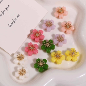 Colorful alloy flower beads with golden centers in a heart-shaped tray for DIY jewelry