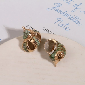 Vue détaillée de breloques en coquillage naturel avec monture dorée pour bijoux DIY