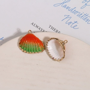Détail macro du pendentif coquillage avec bordure dorée et émail coloré dégradé