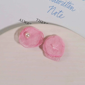Detailaufnahme einer rosa Tüllblume mit Perle auf einem cremefarbenen Präsentationstablett
