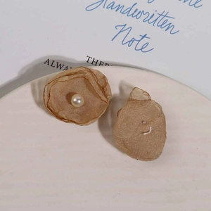 Detail von handgefertigten Mesh-Blumenohrringen in Champagner mit weißer Kunstperle