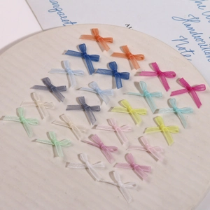 Gros plan de nœuds en organza pastel dans un plateau en céramique pour décor d'ongles