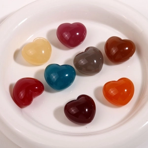 Lot de sept cabochons en résine en forme de cœur translucide pour le bricolage sur plat blanc