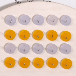 Close-up of pastel purple and yellow round acrylic stud earring components in grid