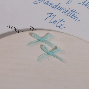Gros plan de deux nœuds en organza bleu clair pour le nail art et la décoration DIY