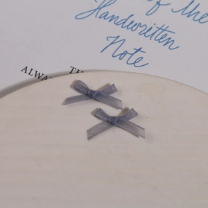 Détail macro de deux nœuds en maille organza bleu clair sur un plateau en céramique blanc