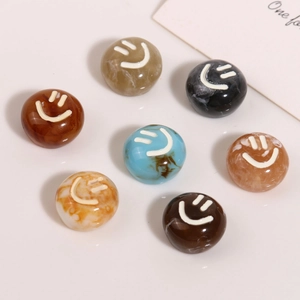 Macro shot of colorful resin smiley face charms with marble and tortoiseshell patterns