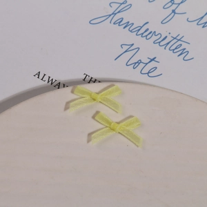 Détail de nœuds en organza jaune sur une assiette en céramique pour accessoires cheveux DIY