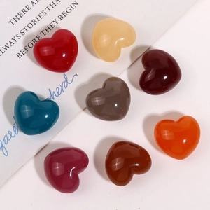 Vue macro de breloques en forme de cœur en résine brillante pour bijoux et artisanat DIY
