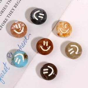 Detailed macro view of round resin charms with marble textures and white smiley face designs