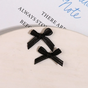 Macro detail of two black organza 3D mesh bow accessories for nail art and DIY jewelry